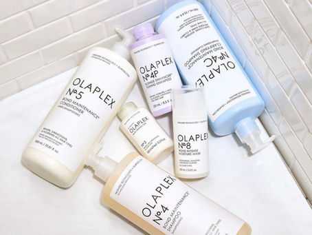 Assorted Olaplex hair care products arranged on a tiled surface.