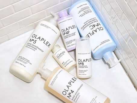 Assorted Olaplex hair care products arranged on a tiled surface.